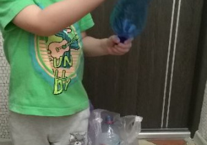 Chłopiec segreguje butelki
