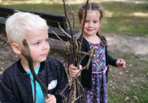 Dziewczynka i chłopiec szukają darów jesieni