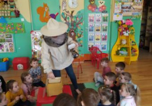 Nauczycielka prezentuje ubranie pszczelarza