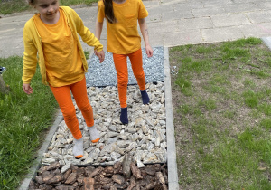 Dziewczynki spacerują po ścieżce sensorycznej