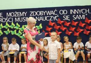 Chłopiec otrzymuje dyplom ukończenia przedszkola