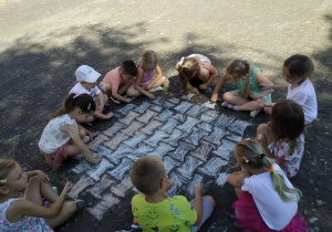 Dzieci malują barwny dywan
