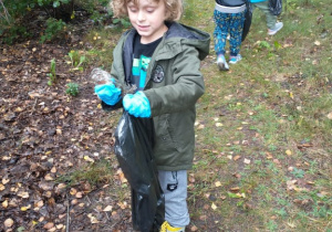 Chłopiec sprząta las