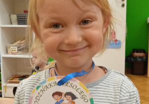 Dziewczynka z medalem przedszkolaka