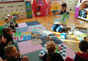 Dzieci słuchają zasad gry planszowej