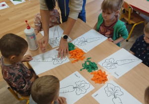 Dzieci wyklejają marchewki