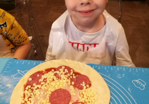 Chłopiec z własnoręcznie wykonaną pizzą