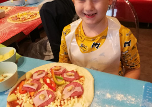 Chłopiec z własnoręcznie wykonaną pizzą