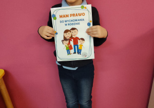 Chłopiec z tablicą edukacyjną związaną z prawami dziecka