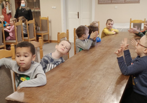Dzieci słuchają informacji na temat ozdób choinkowych