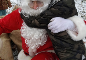Chłopiec przytula się do św. Mikołaja