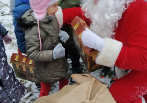 Św. Mikołaj rozdaje dzieciom prezenty