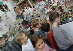 Dzieci oglądają bombki w sklepiku