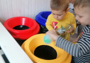 Chłopiec wrzuca śmieci do odpowiedniego kosza