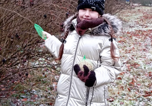 Dziewczynka zawiesza ekologiczny karmnik