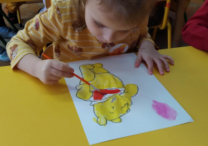 Dziewczynka maluje Kubusia Puchatka