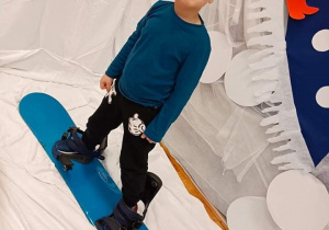 Chłopiec na desce snowboardowej