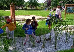 Dzieci podlewają rośliny