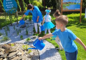 Dzieci podlewają ogródek