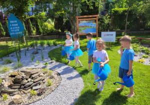 Dzieci podlewają roślinki w ogrodzie