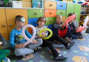 Dzieci siedzą z balonowymi stworkami