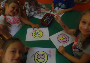 Przedszkolaki kolorują uśmiechnięte buźki