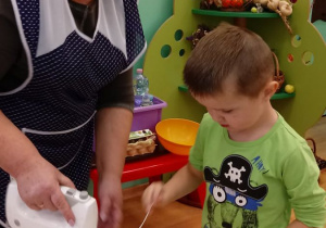 Chłopiec dodaje mąki do ciasta