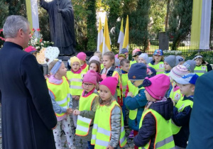 Dzieci stoją pod pomnikiem Jana Pawła II