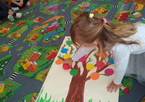 Dzieci układają kropkowe drzewo