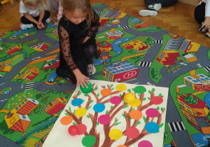 Dzieci układają kropkowe drzewo
